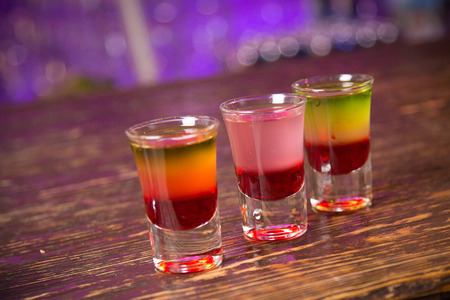 an alcoholic cocktail from layers is in beautiful glass, on the barの写真素材