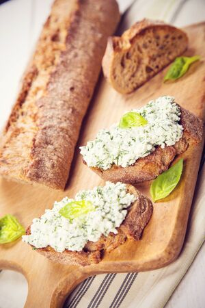 fresh bruschetta with cheese and parsley on wooden plate in studioの写真素材