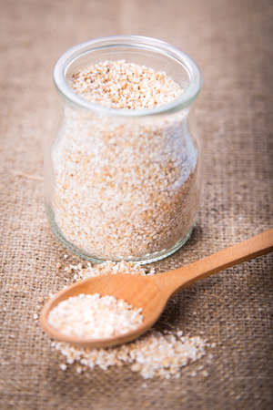wheat groats in glass tableware with a spoon in a studioの写真素材