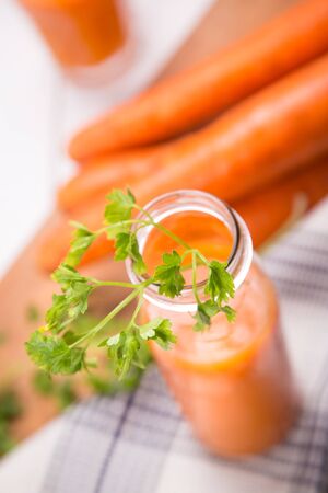 fresh carrot juice in glass on a wooden backgroundの写真素材