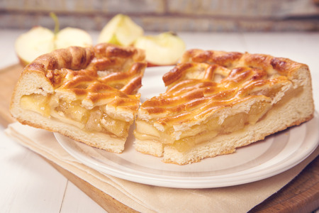 pieces of fresh apple-pie with filling on a wooden backgroundの写真素材
