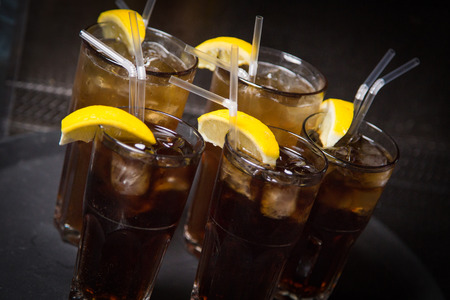 an alcoholic brown cocktail is in beautiful glass, on the barの写真素材