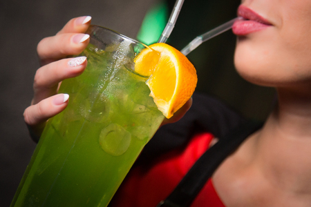 an alcoholic green cocktail is in beautiful glass, in the handの写真素材
