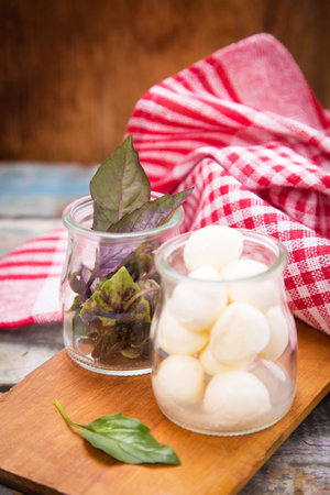 fresh mozzaella with basilicas on wooden plate in studioの写真素材