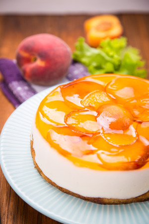 peach pie on plate with fresh peaches and lettuce in studioの写真素材