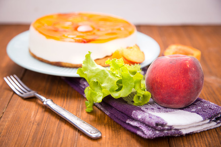 peach pie on plate with fresh peaches and lettuce in studioの写真素材
