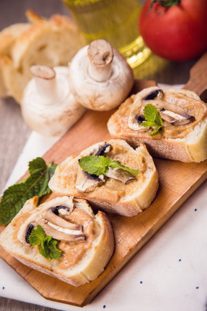 bread with pate,fried mushrooms and mint on wooden plateの写真素材