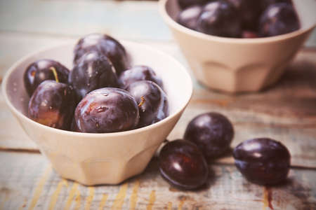 fresh raw ripe blue plums in crokery dishの写真素材