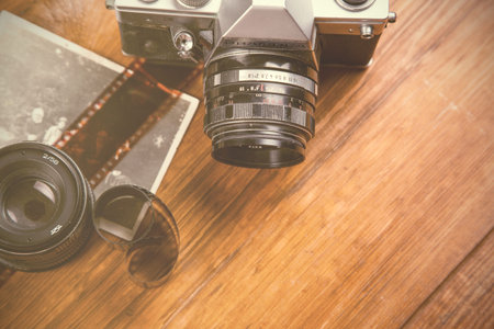 old retro camera with old picture on wooden surface