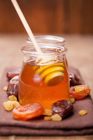fresh  translucent flowers honey in glass container with dry fruitsの写真素材