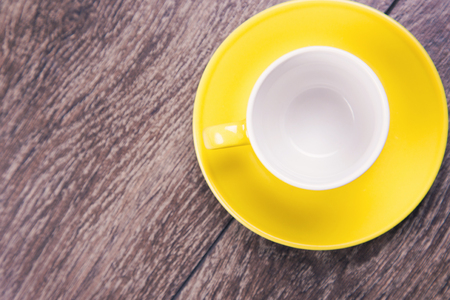 new yellow empty cup on black wooden backgroundの写真素材