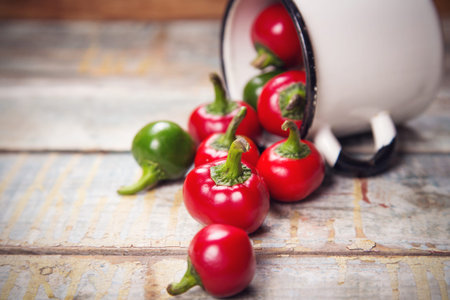 many raw ripe red and green pepper on wooden backgroundの写真素材