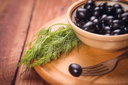 olives and green fresh dill, on a wooden backgroundの写真素材