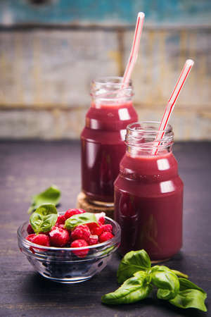 cold drink from frozen berry with fresh basil on wooden backgroundの写真素材