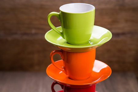 some colored empty cups on brown wooden backgroundの写真素材