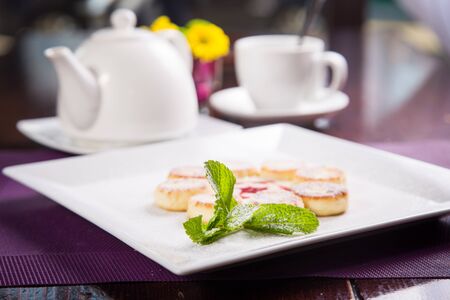 fresh cheese pancakes with mint on white dishの写真素材