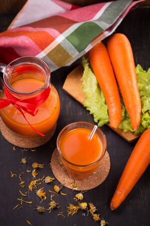 fresh carrot juice in glass and ripe raw carrot in studioの写真素材