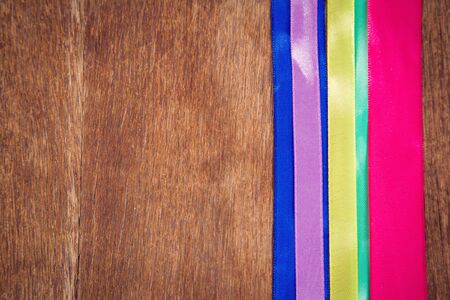 some decorative colored ribbon on wooden backgroundの写真素材