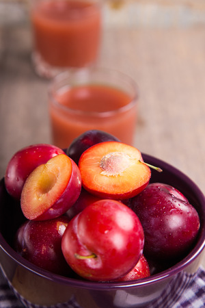 many fresh ripe wet plum with juice in glassの写真素材