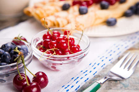 pancakes with cherry,blueberry and red currant and pitcher of milkの写真素材