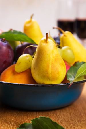 autumn apples,blue plums,peach and grape with red wine in dishの写真素材
