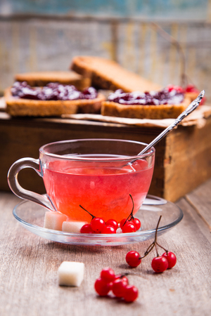 fresh hot viburnum tea in glass on wooden backgroundの写真素材