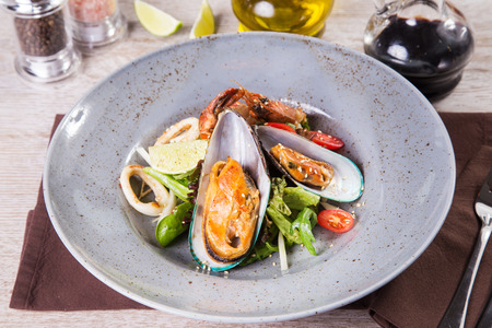salad with seafood,vegetables and lemon mixed in grey dishの写真素材