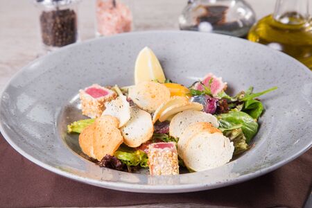 salad with fresh tuna and yolk,vegetables  mixed in grey dishの写真素材