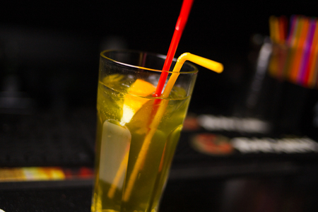 yellow alcoholic cocktail in transparent glass with citrusの写真素材