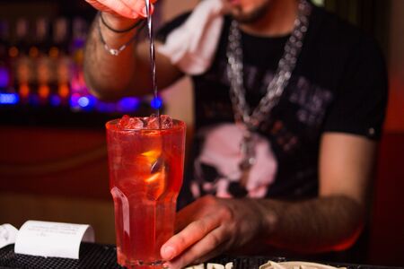 an alcoholic colored cocktails is in beautiful glass,pours in the restaurantの写真素材