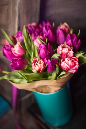 bouquet with violet and pink fresh tulips in blue vaseの写真素材