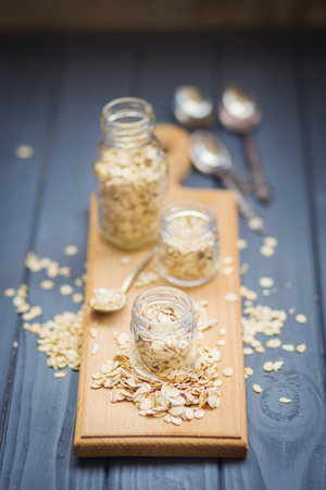 Oat flakes in a transparent jar on a wooden backgroundの写真素材