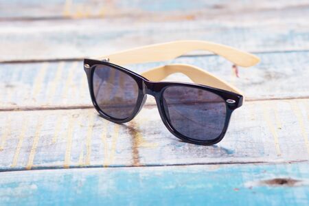 stylish black modern sunglasses in studio on wooden backgroundの写真素材