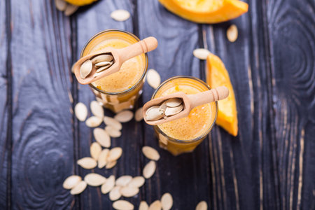 delicious pumpkin smoothie with seeds in studio on wooden backgroundの写真素材