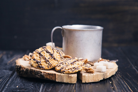 hot fresh tea in old mug with delicious cookie on wooden backgroundの写真素材