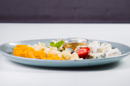 cheese plate with oil,strawberry and mint isolated on whiteの写真素材