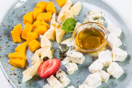 cheese plate with oil,strawberry and mint isolated on whiteの写真素材