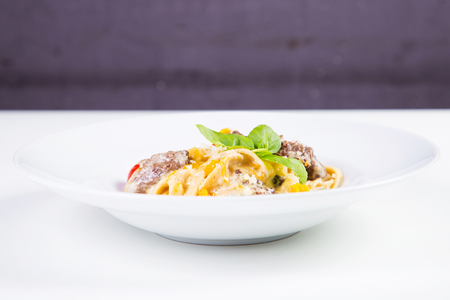 pasta with veal,tomatoes and basil isolated on whiteの写真素材