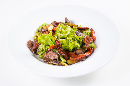 health salad with hot fresh liver and vegetables isolated on whiteの写真素材