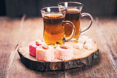 cups of tea with multicolored Turkish Delight on wooden backgroundの写真素材