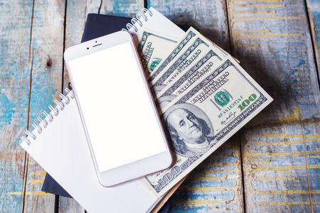 Business accounting with notebook ,smartphone and american dollarsの写真素材