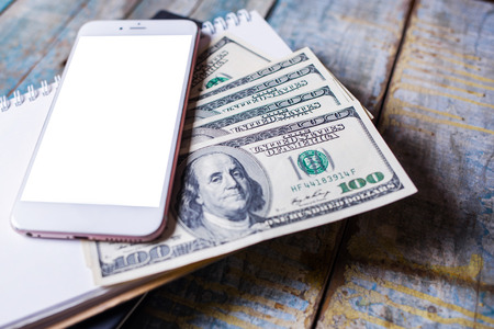 Business accounting with notebook ,smartphone and american dollarsの写真素材