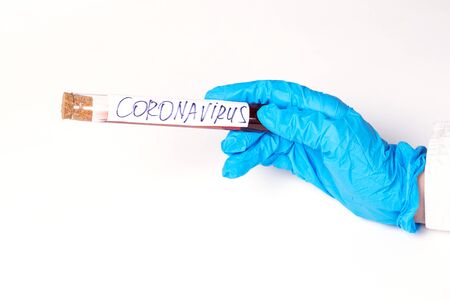 Coronavirus Covid 19 infected blood sample in sample tube in hand of scientist doctor biohazard protection clothing in coronavirus covid 19 research laboratoryの写真素材