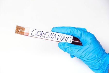 Coronavirus Covid 19 infected blood sample in sample tube in hand of scientist doctor biohazard protection clothing in coronavirus covid 19 research laboratoryの写真素材