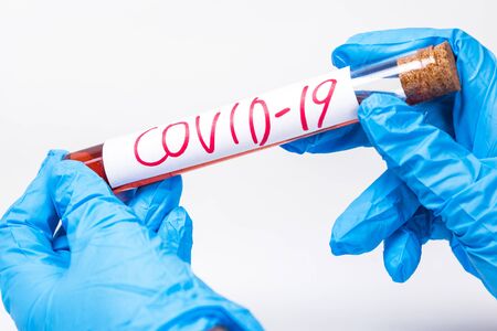 Coronavirus Covid 19 infected blood sample in sample tube in hand of scientist doctor biohazard protection clothing in coronavirus covid 19 research laboratoryの写真素材