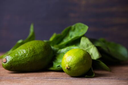 Fresh harvested spinach, lime and avocado on a old grungy table.の写真素材