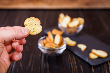 A stack of round crackers with herbal and salt on a  black plate background.