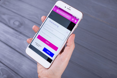 Kyiv, Ukraine - 15 May 2020: Hands holding a smartphone with Wizzair  on display screen, Illustrative Editorialのeditorial素材