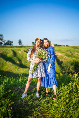 two young european beautiful girls in a field of wildflowersの写真素材
