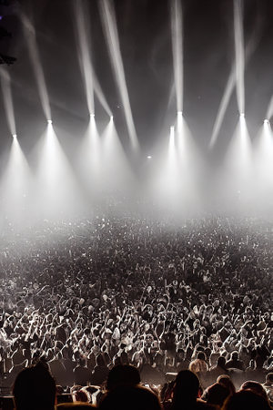 An atmospheric image of a music concert audience, featuring silhouettes of fans and misty stage lights in the background, Ai-generated illustrationの素材